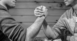 Image depicting two men arm-wrestling. Symbolizing the ongoing struggle of the crypto industry against Biden administration.