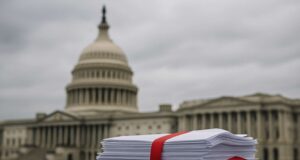 A stack of legislative documents bound with red tape sits on a stone ledge in front of the blurred US Capitol building under overcast skies, symbolizing stalled US crypto regulation and Congressional gridlock.