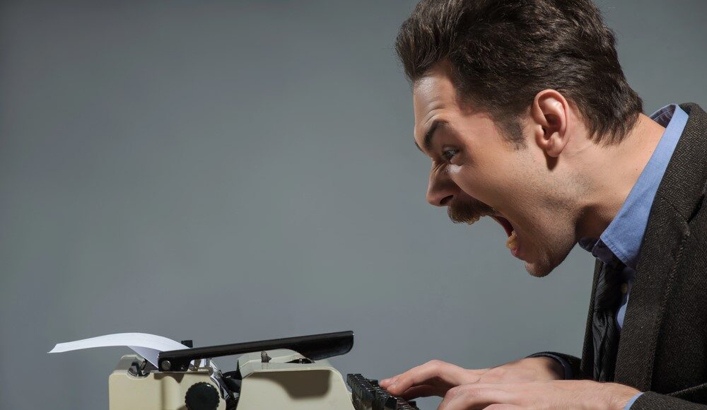 Legal clerk typing a letter on an old fashioned typewriter with ICBA logo, screaming as he drafts his letter to the OCC.
